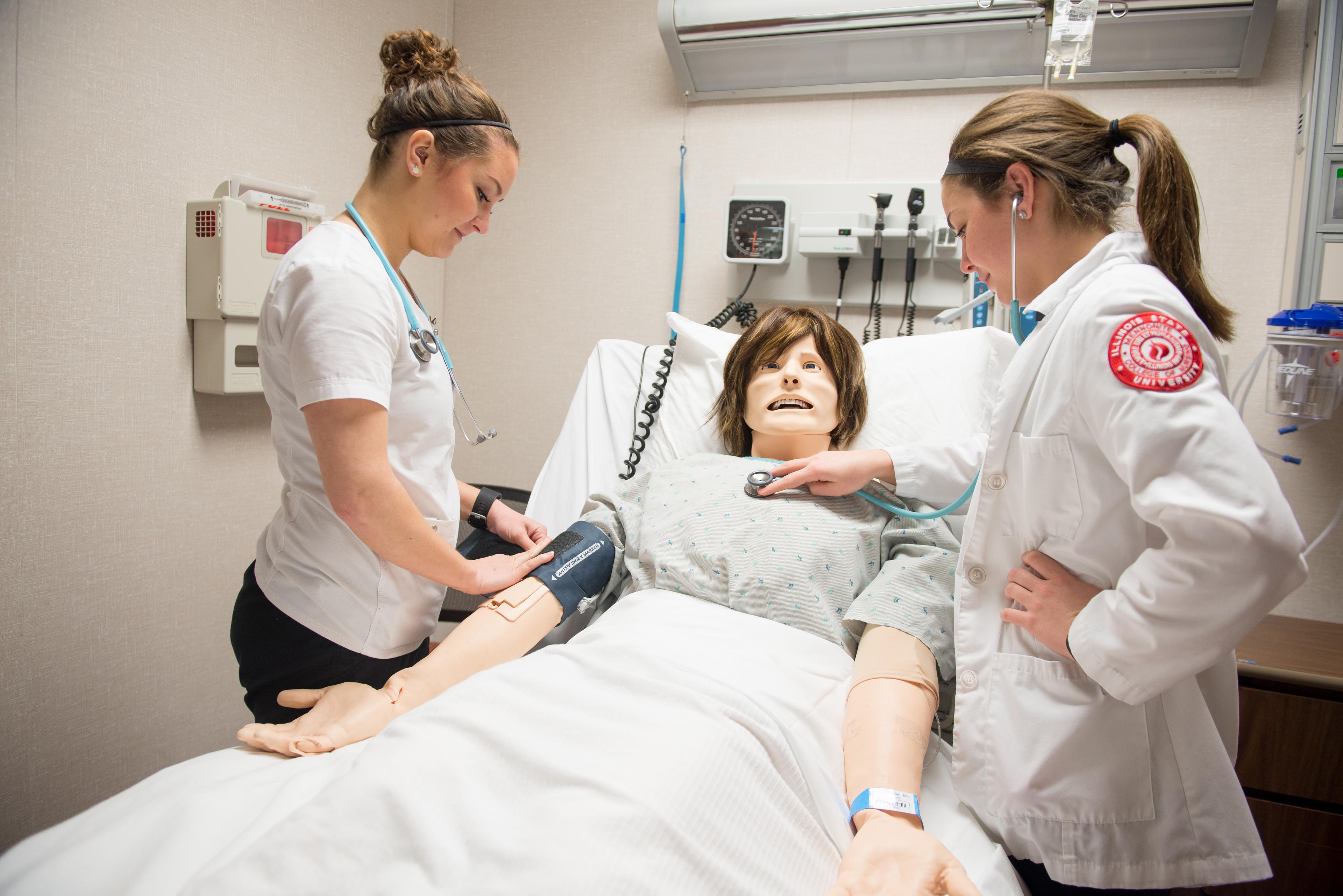 ISU female nurse students working on dummy patient taking vitals_33660.jpg